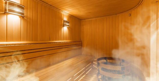 An empty wooden clad sauna filled with steam