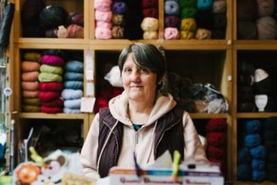 Woman hosting a market stall with knitting supplies