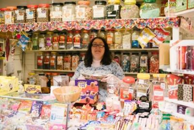 Woman hosting an indoor market sweet shop