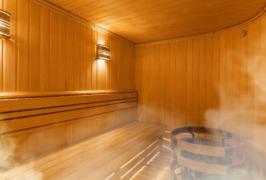 An empty wooden clad sauna filled with steam